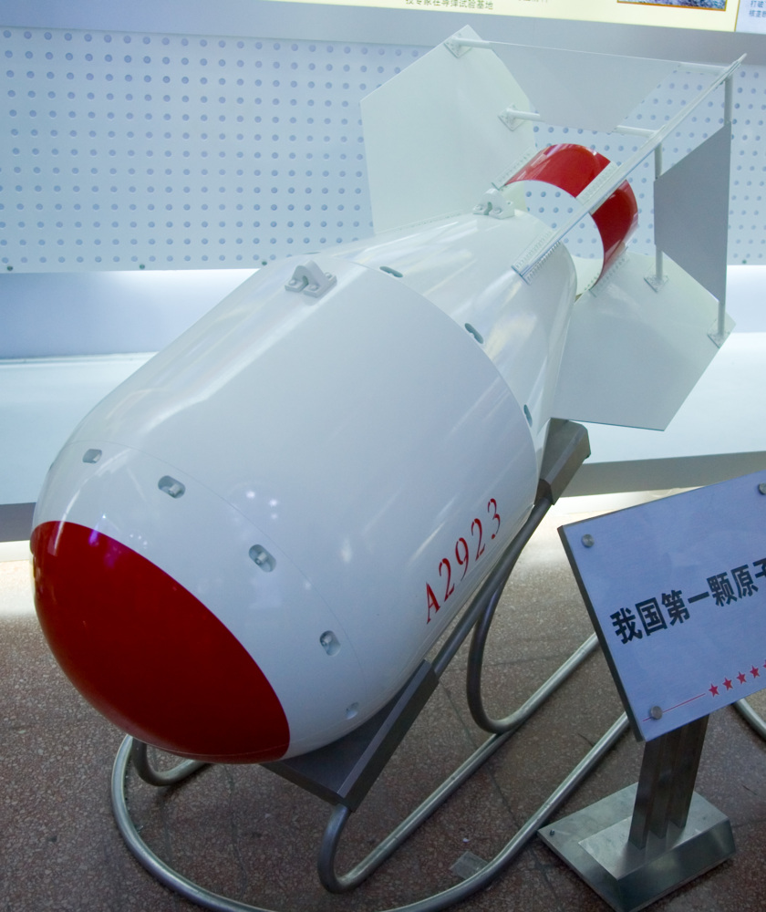 Chinese nuclear bomb on display at "Our troops towards the Sky". Podium says: "Our first atom bomb." (Src. Wikimedia Commons)